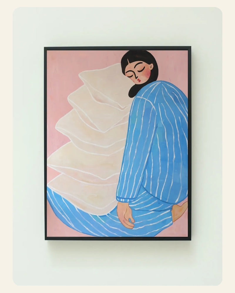 Carefree art print showing a seated figure in blue striped clothing leaning against oversized cream pillows on a blush background.