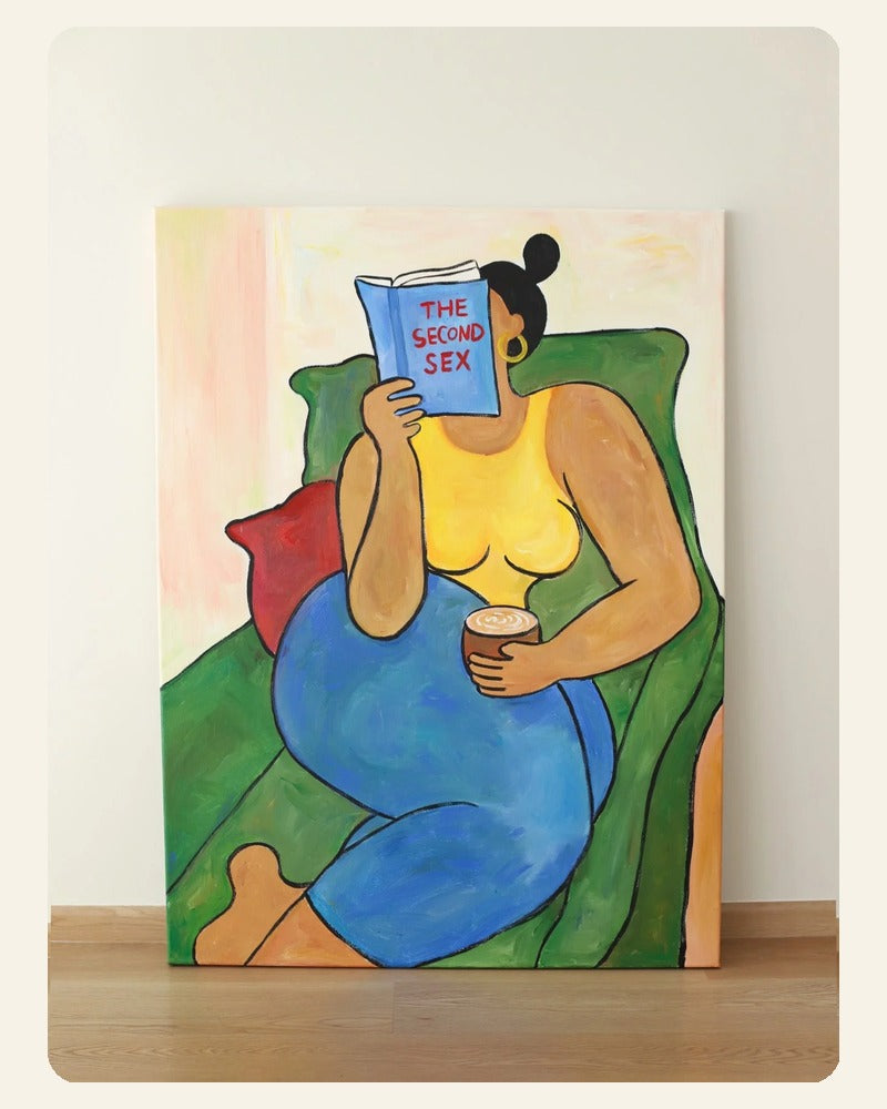 Reading Woman art print showing a seated woman in a green chair holding a book.